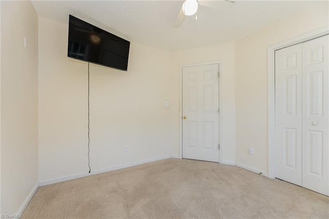 unfurnished bedroom with ceiling fan and light colored carpet