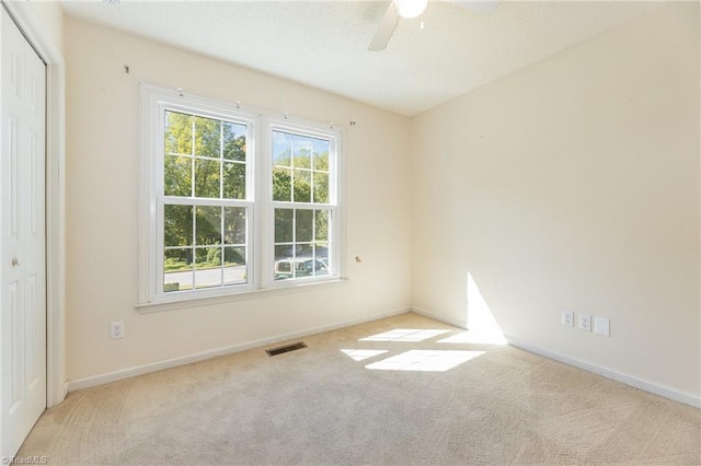 carpeted spare room with ceiling fan