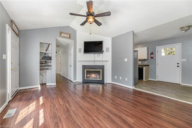 unfurnished living room featuring dark hardwood / wood-style floors, ceiling fan, and vaulted ceiling