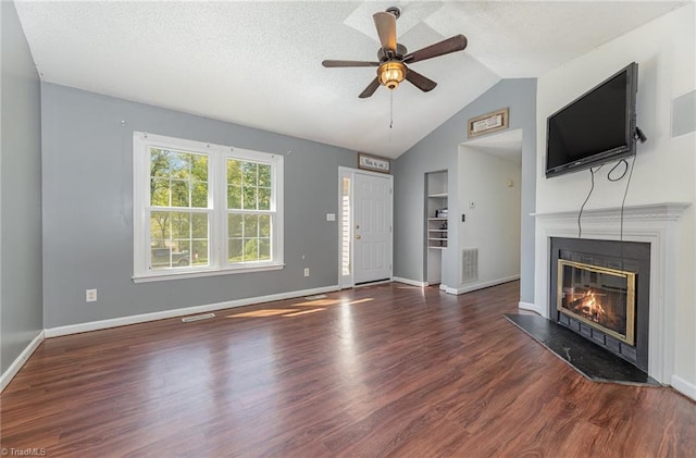 unfurnished living room with dark hardwood / wood-style floors, ceiling fan, lofted ceiling, and a textured ceiling