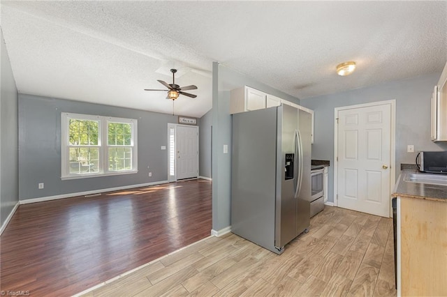 kitchen with ceiling fan, light hardwood / wood-style flooring, a textured ceiling, white cabinets, and appliances with stainless steel finishes