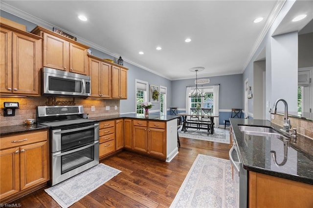 8483 Austin Hill Ln, Tobaccoville, NC 27050 - kitchen featuring appliances with stainless steel finishes, a peninsula, crown molding, dark wood-type flooring, and dark stone counters