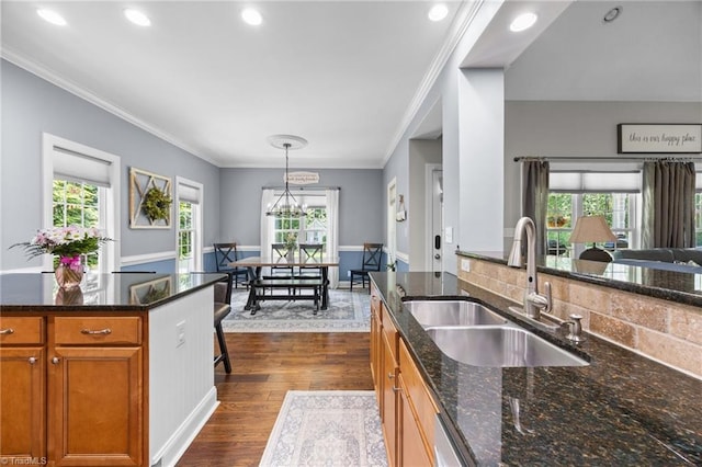 8483 Austin Hill Ln, Tobaccoville, NC 27050 - kitchen featuring crown molding, dark wood-style flooring, brown cabinetry, recessed lighting, and dark stone counters