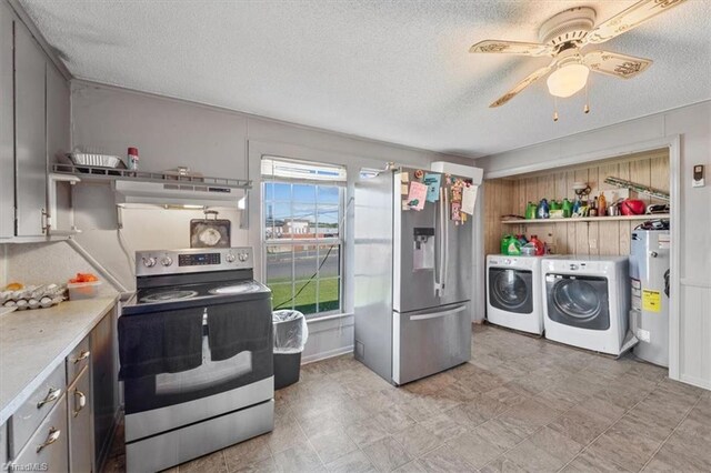 kitchen featuring a textured ceiling, appliances with stainless steel finishes, electric water heater, washing machine and dryer, and ceiling fan