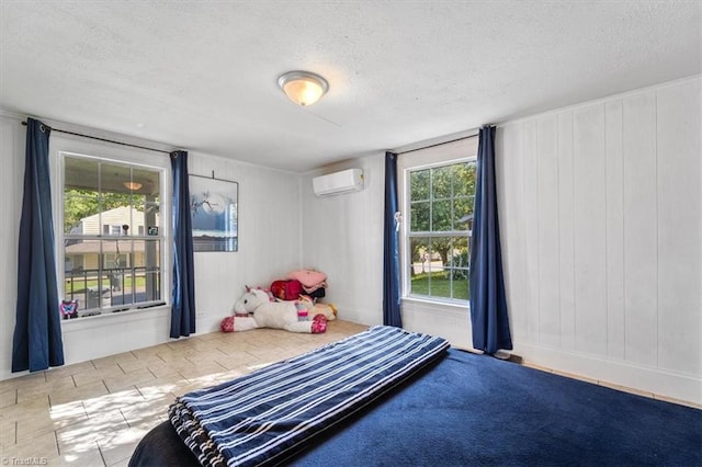 bedroom with a textured ceiling and an AC wall unit