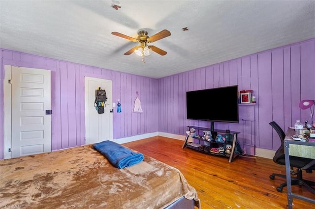 bedroom featuring hardwood / wood-style floors, ceiling fan, and a textured ceiling