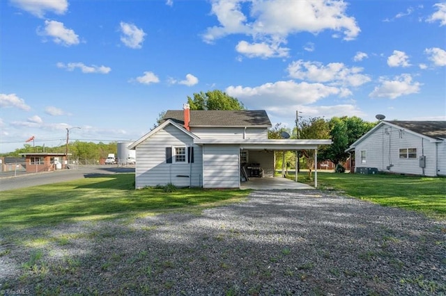 view of front of house featuring a carport and a front yard