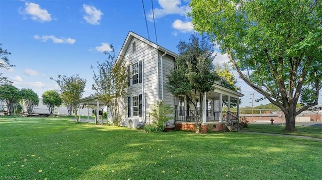 rear view of house featuring a yard and covered porch