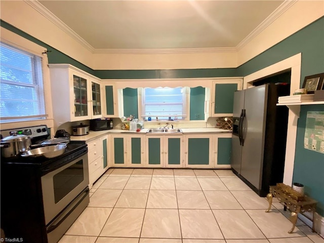 1415 E 4th St, Winston-Salem, NC 27101 - kitchen with appliances with stainless steel finishes, light countertops, crown molding, light tile patterned floors, and glass insert cabinets