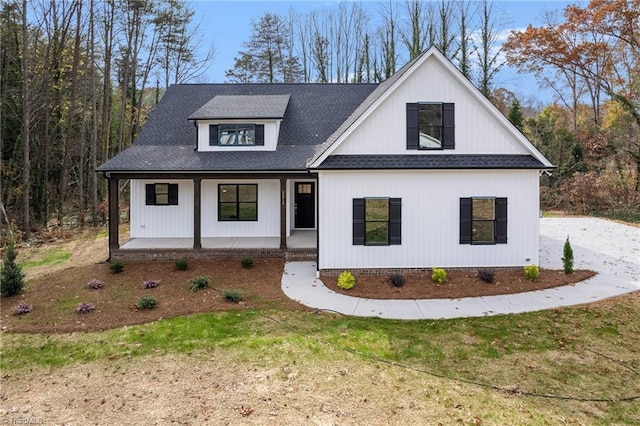 modern farmhouse style home featuring a front yard and a porch