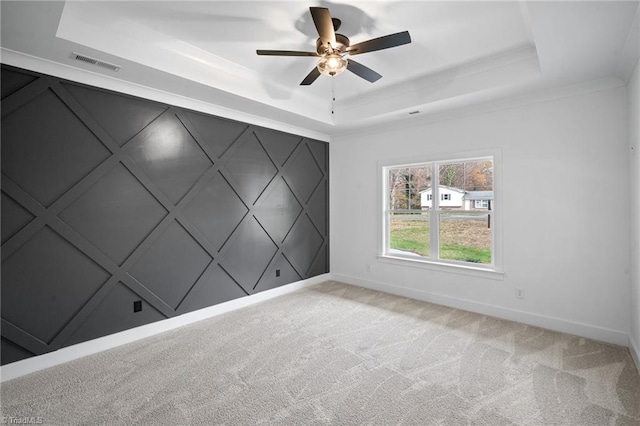 unfurnished room with light colored carpet, a raised ceiling, and ceiling fan