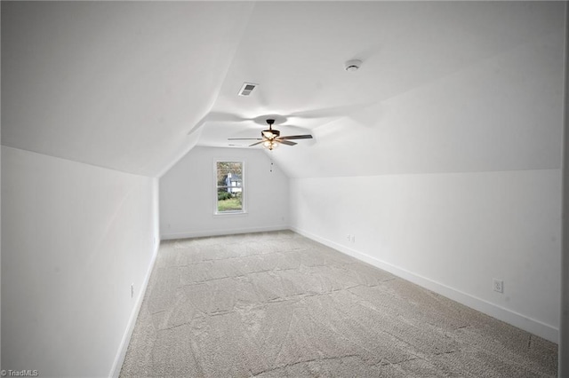 additional living space featuring ceiling fan, light colored carpet, and vaulted ceiling