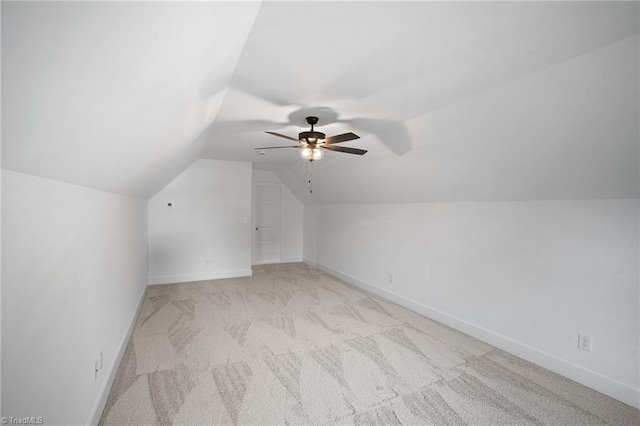 additional living space with ceiling fan, light colored carpet, and vaulted ceiling