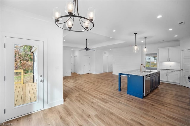 kitchen featuring sink, a kitchen island with sink, hanging light fixtures, white cabinets, and stainless steel dishwasher