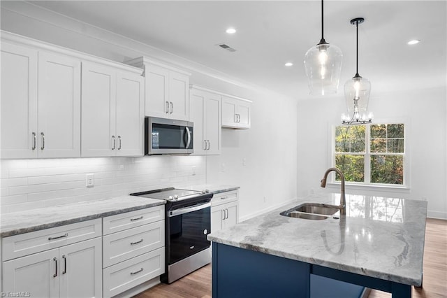 kitchen featuring white cabinetry, appliances with stainless steel finishes, sink, and a kitchen island with sink