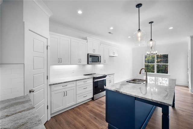 kitchen with a kitchen island with sink, sink, stainless steel appliances, and white cabinets