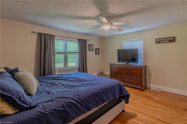 bedroom featuring visible vents, wood finished floors, ceiling fan, and crown molding