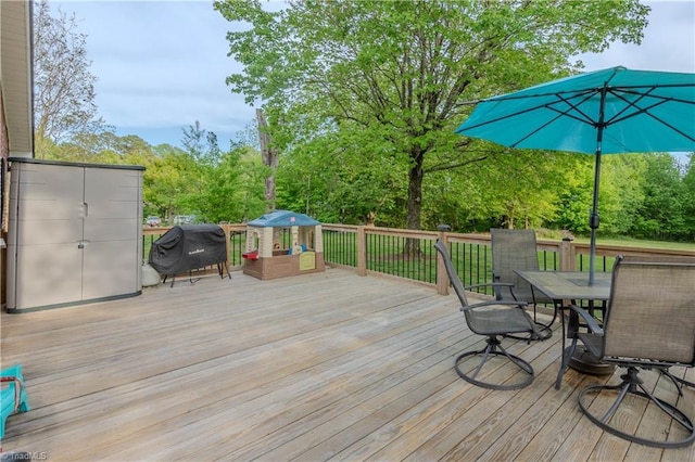 wooden deck featuring a grill and outdoor dining space