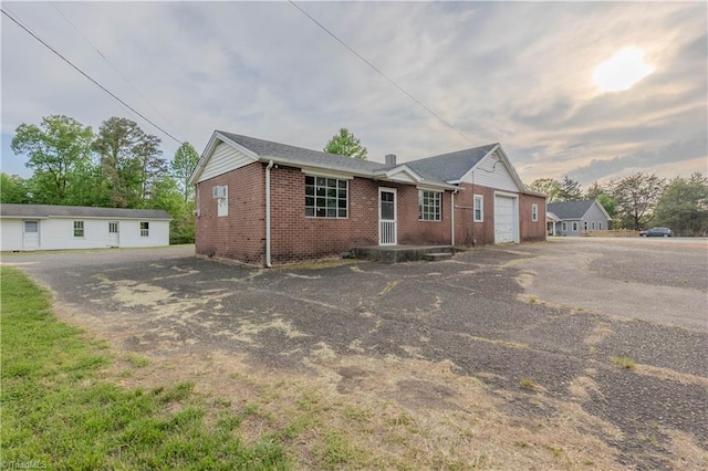 ranch-style house featuring an attached garage, brick siding, and driveway