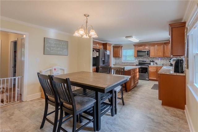 dining space featuring an inviting chandelier, crown molding, and baseboards