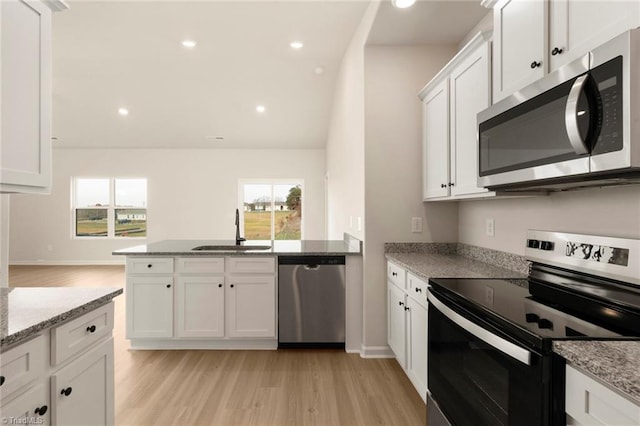 1047 Russell Dr, Winston-Salem, NC 27127 - kitchen featuring a peninsula, stainless steel appliances, recessed lighting, white cabinetry, and a sink