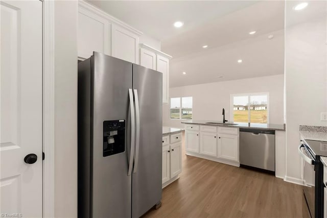 1047 Russell Dr, Winston-Salem, NC 27127 - kitchen with light wood finished floors, a sink, white cabinets, and appliances with stainless steel finishes