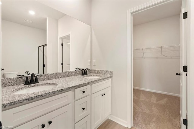1047 Russell Dr, Winston-Salem, NC 27127 - full bath with double vanity, a sink, a walk in closet, and visible vents