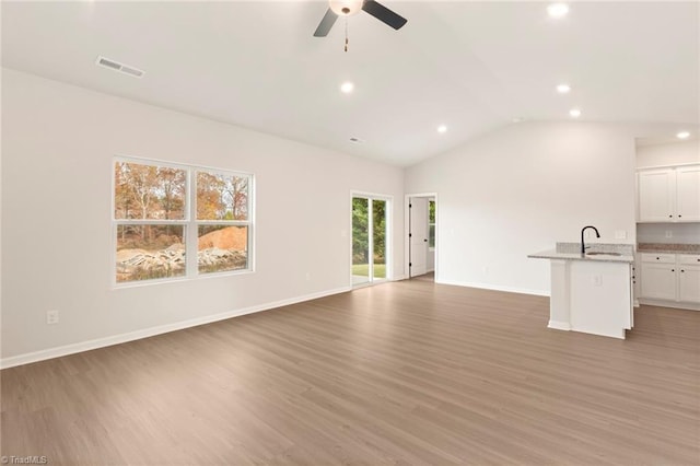 1047 Russell Dr, Winston-Salem, NC 27127 - unfurnished living room featuring a sink, light wood-style flooring, ceiling fan, and visible vents