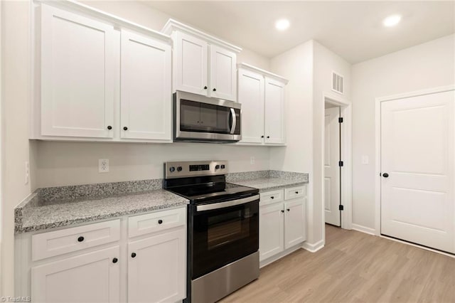 1047 Russell Dr, Winston-Salem, NC 27127 - kitchen with light wood-style flooring, visible vents, stainless steel appliances, recessed lighting, and white cabinetry