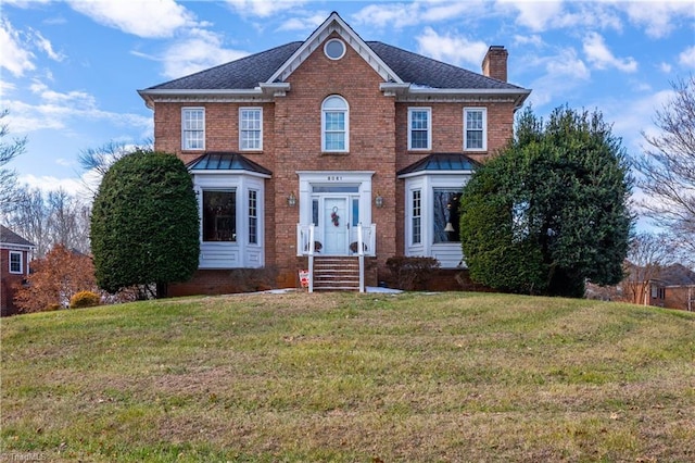 colonial home featuring a front lawn