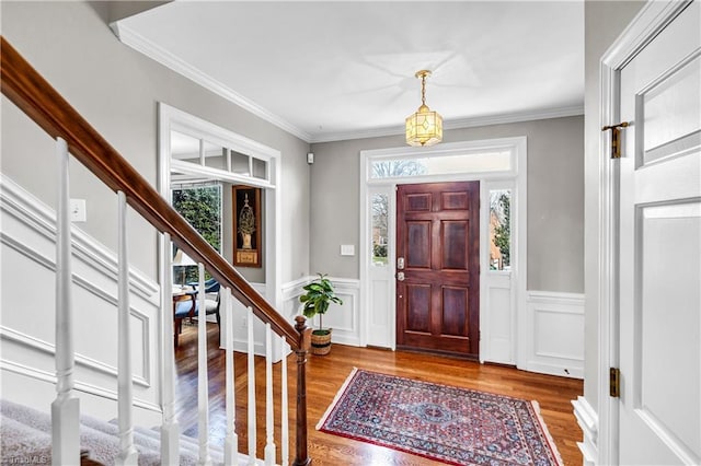 foyer featuring wood-type flooring and ornamental molding