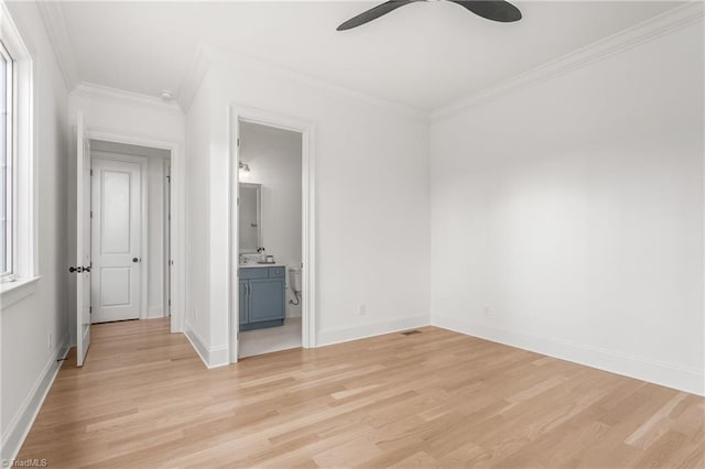 spare room with baseboards, light wood finished floors, and crown molding