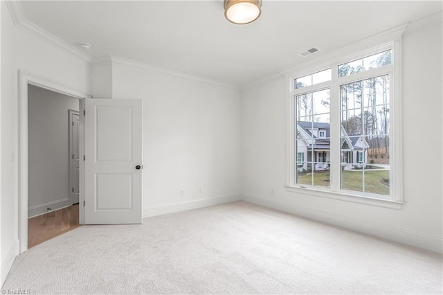 empty room with plenty of natural light, visible vents, and crown molding