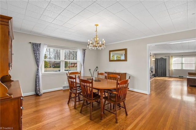 dining area with plenty of natural light, light wood-type flooring, baseboards, and ornamental molding