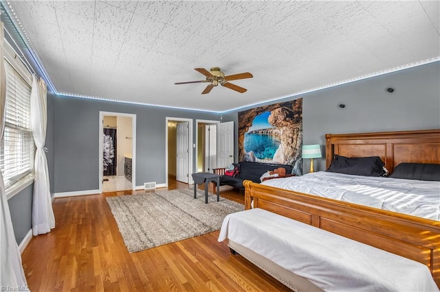 bedroom featuring baseboards, wood finished floors, and a ceiling fan