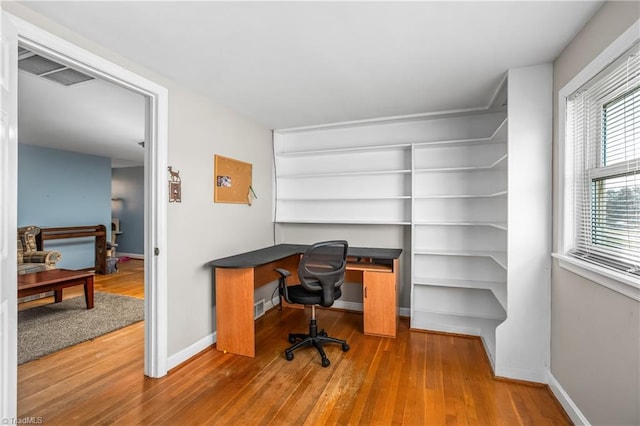 office area featuring visible vents, baseboards, and wood finished floors