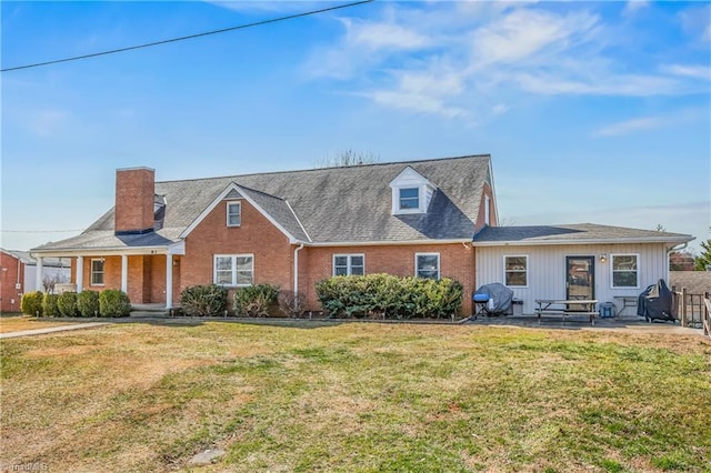 view of front of property with brick siding, a patio, a front yard, and fence