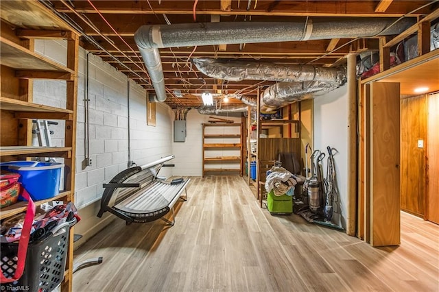 unfinished basement featuring electric panel and wood finished floors