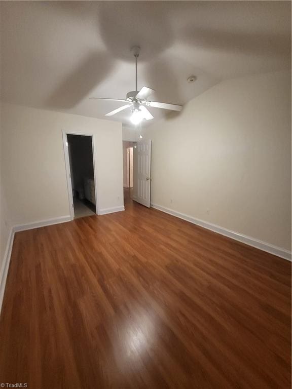 unfurnished bedroom featuring baseboards, a ceiling fan, wood finished floors, and vaulted ceiling