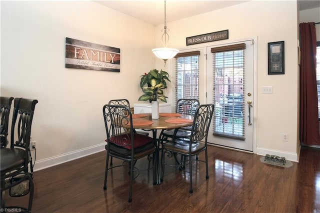 dining space with baseboards and wood finished floors