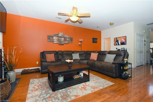 living room with visible vents, baseboards, ceiling fan, and wood finished floors