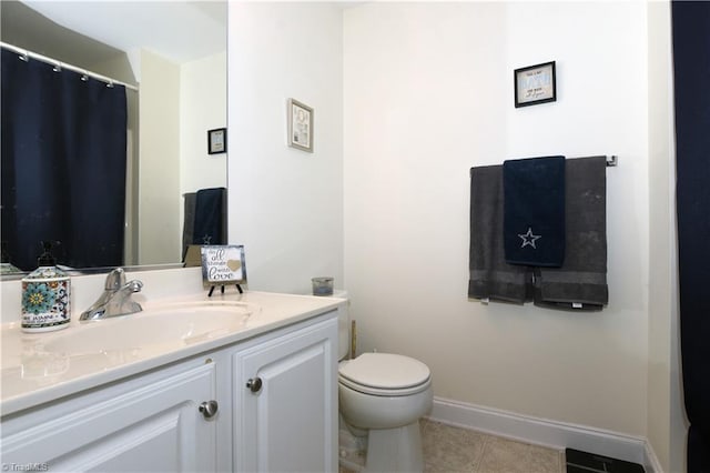 bathroom with toilet, tile patterned floors, baseboards, and vanity