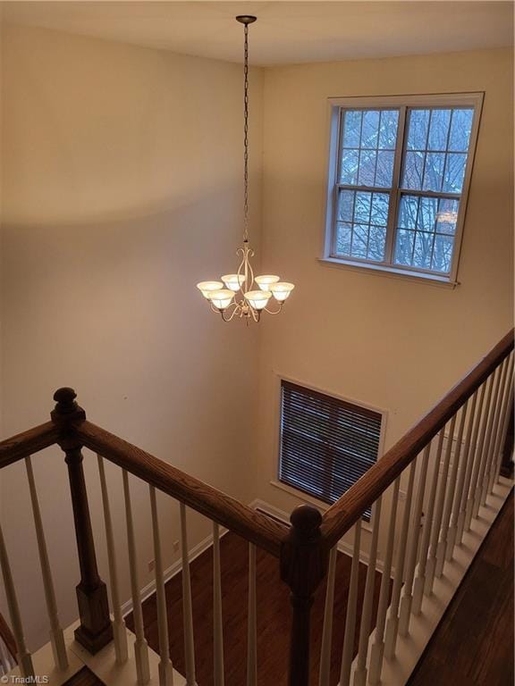 stairs featuring visible vents, wood finished floors, and a chandelier