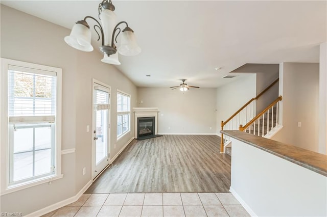 unfurnished living room with light hardwood / wood-style floors and ceiling fan with notable chandelier