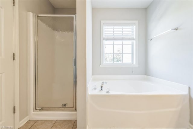 bathroom featuring tile patterned flooring and shower with separate bathtub