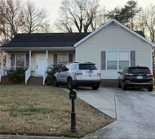 ranch-style house featuring a porch and a front yard