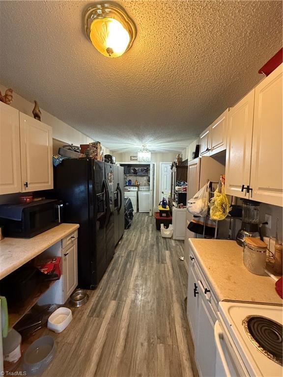 kitchen with washer and clothes dryer, black appliances, dark hardwood / wood-style floors, a textured ceiling, and white cabinetry