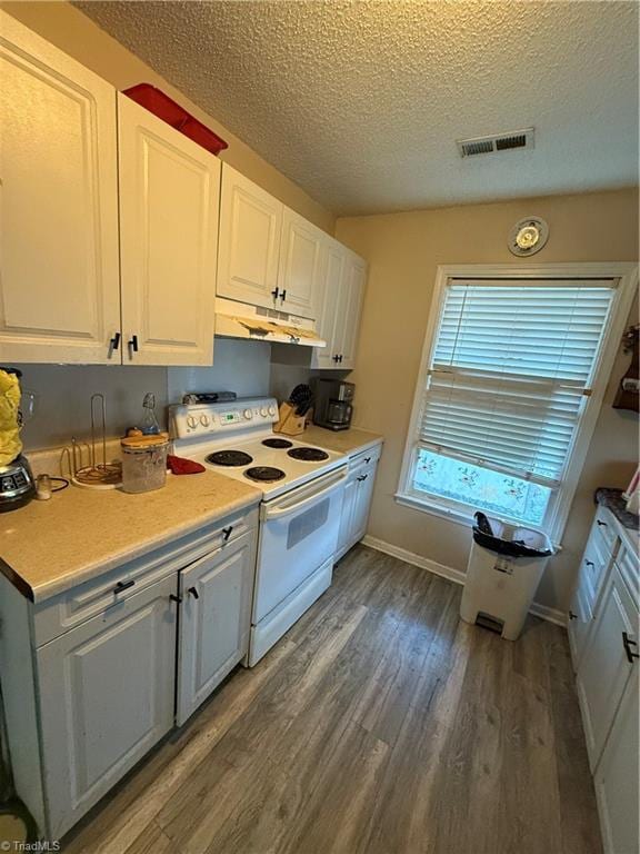 kitchen featuring electric stove, white cabinetry, dark hardwood / wood-style flooring, and a textured ceiling