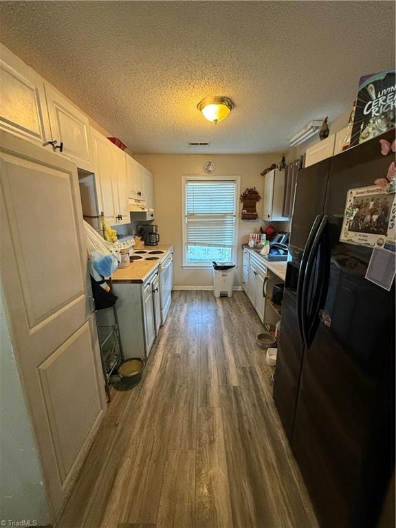 kitchen with wooden counters, black fridge with ice dispenser, a textured ceiling, dark hardwood / wood-style floors, and white cabinetry