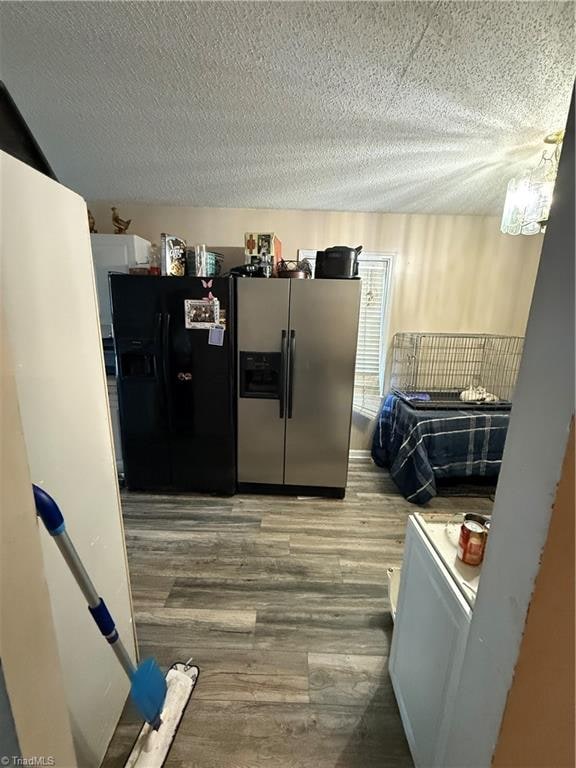 kitchen with white cabinets, stainless steel fridge with ice dispenser, a textured ceiling, and hardwood / wood-style floors